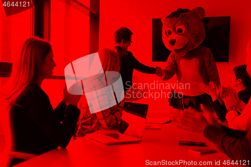 Image of boss dresed as bear having fun with business people in trendy of