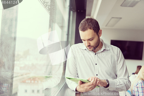 Image of Businessman Using Tablet In Office Building by window