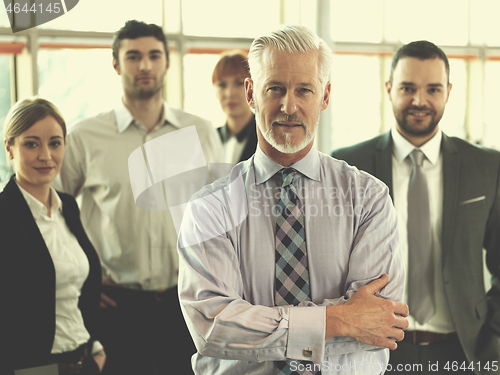 Image of senior business man with his team at office