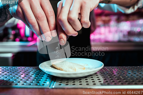 Image of Expert barman is making cocktail at night club.