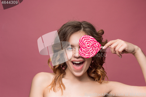 Image of beauty portrait of a cute girl in act to eat a candy