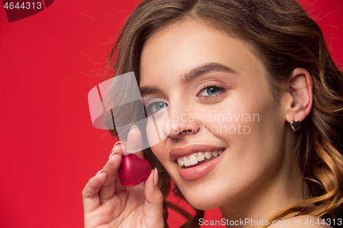 Image of beauty portrait of a cute girl in act to eat a chocolate candy