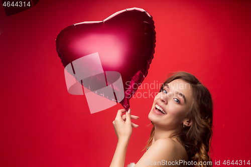 Image of Nice young smiling woman with long wavy silky hair, natural make up looking at camera