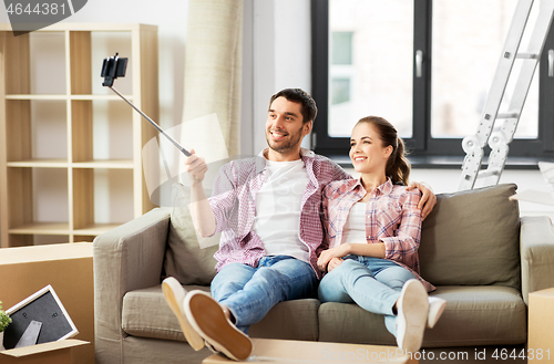 Image of couple taking picture by selfie stick at new home