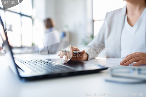 Image of businesswoman with laptop working at office