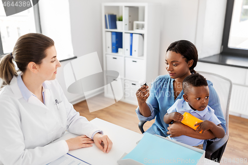 Image of doctor and woman with baby and medicine at clinic