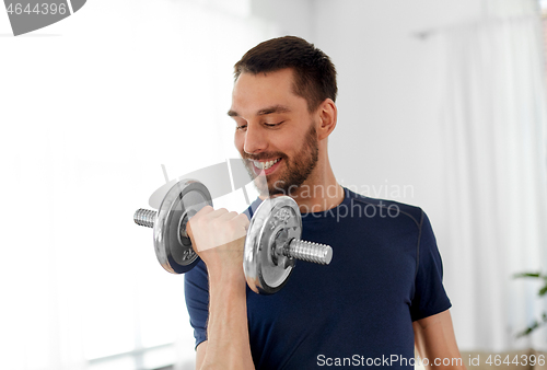 Image of man exercising with dumbbell at home