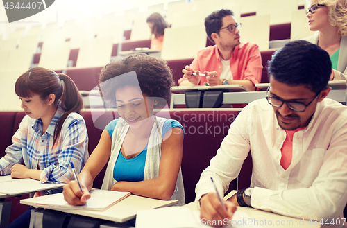 Image of group of students with notebooks in lecture hall