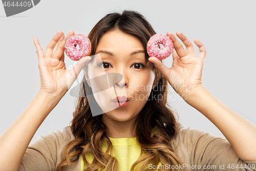 Image of happy asian woman with donuts