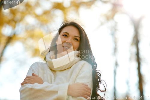 Image of portrait of happy young woman in autumn park