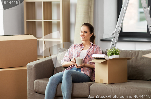 Image of woman moving to new home and drinking coffee