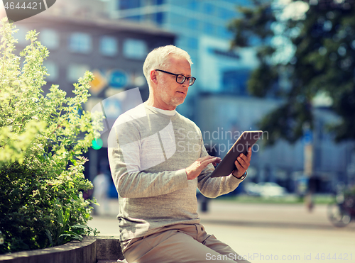 Image of senior man with tablet pc on city street