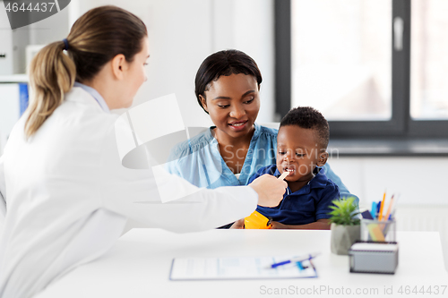 Image of doctor examining african baby\'s mouth at clinic