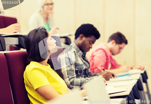 Image of group of students with notebooks in lecture hall