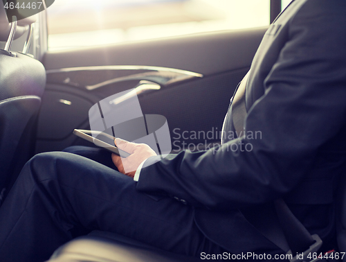 Image of senior businessman with tablet pc driving in car