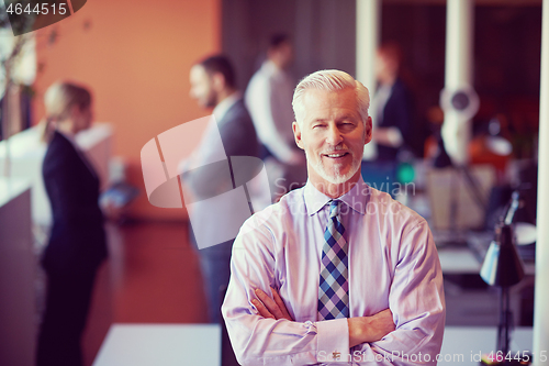 Image of senior business man with his team at office