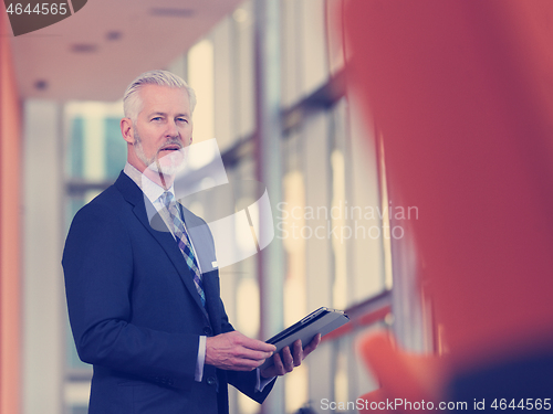 Image of senior business man working on tablet computer