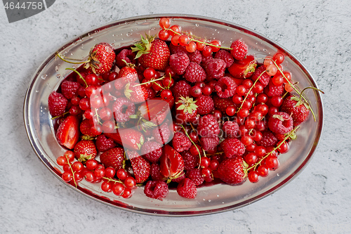 Image of Fresh summer fruit composition. Strawberries, red currants, raspberries placed on metal tray