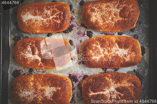 Image of Delicious hot homemade buns stuffed with blueberry on a baking tray