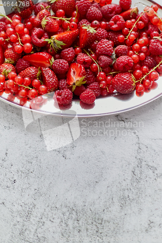 Image of Fresh summer fruit composition. Strawberries, red currants, raspberries placed on metal tray