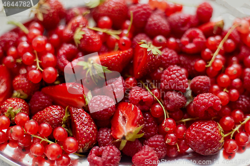 Image of Fresh summer red fruit background composition. Strawberries, red currants, raspberries.