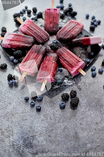 Image of Forrest fruit ice cream on stick. Homemade healthy vegan snack. Placed on plate with ice