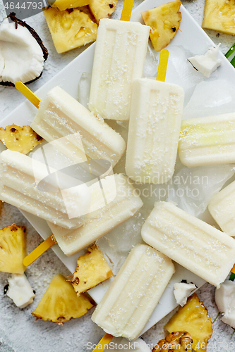 Image of Homemade vegan popsicles made with coconut milk and pineapple. Delicious healthy summer snack