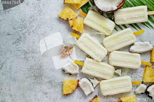 Image of Homemade pineapple coconut popsicles on stone background. Summer food concept with copy space