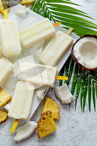 Image of Homemade vegan popsicles made with coconut milk and pineapple. Delicious healthy summer snack