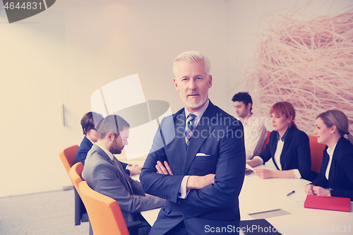 Image of senior business man with his team at office