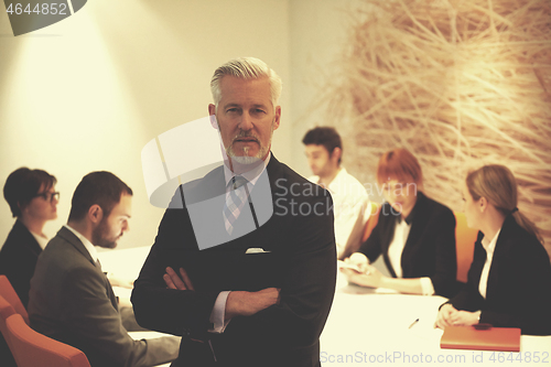 Image of senior business man with his team at office