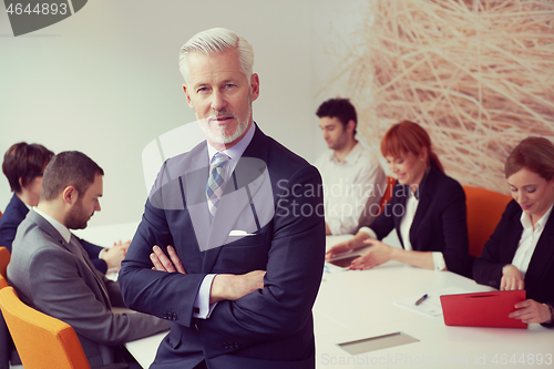 Image of senior business man with his team at office