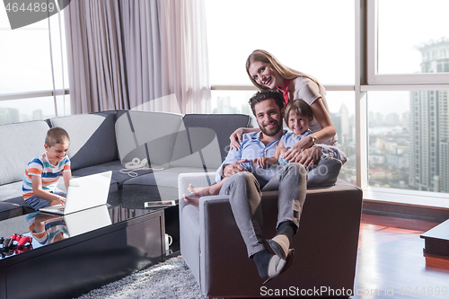 Image of happy young couple spending time with kids