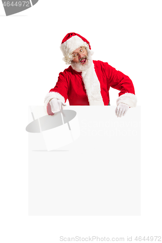 Image of Happy Santa Claus pointing on blank advertisement banner background with copy space. Smiling Santa Claus pointing in white blank sign