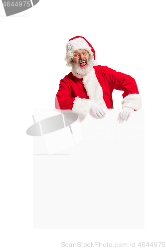 Image of Happy Santa Claus pointing on blank advertisement banner background with copy space. Smiling Santa Claus pointing in white blank sign