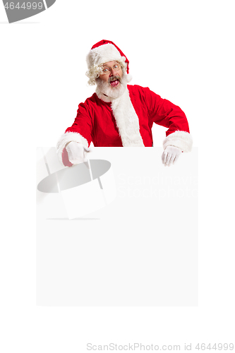 Image of Happy Santa Claus pointing on blank advertisement banner background with copy space. Smiling Santa Claus pointing in white blank sign