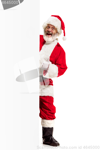 Image of Happy Santa Claus pointing on blank advertisement banner background with copy space. Smiling Santa Claus pointing in white blank sign