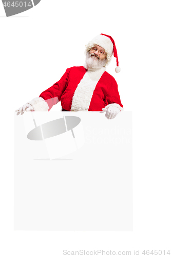 Image of Happy Santa Claus pointing on blank advertisement banner background with copy space. Smiling Santa Claus pointing in white blank sign