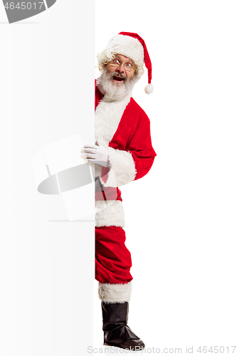 Image of Happy Santa Claus pointing on blank advertisement banner background with copy space. Smiling Santa Claus pointing in white blank sign