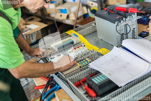 Image of Electrician assembling industrial electric cabinet in workshop