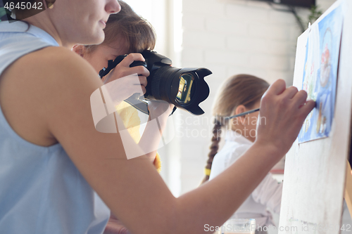 Image of Girl takes pictures of how the artist works