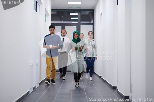 Image of multi-ethnic startup business team walking through the hallway