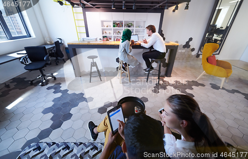 Image of group of casual multiethnic business people taking break from th