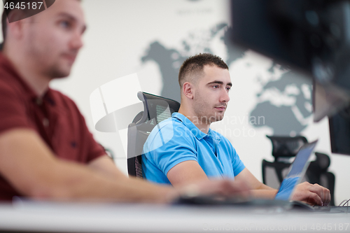 Image of two male software developers working on computer