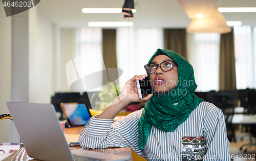 Image of african muslim business woman using mobile phone