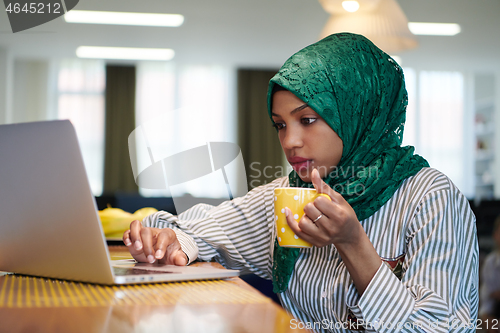 Image of african muslim business woman drinking tea