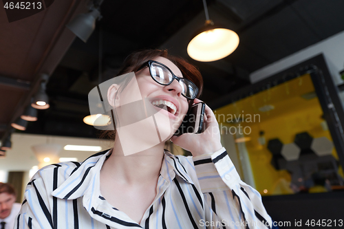 Image of portrait of businesswoman with glasses using mobile phone