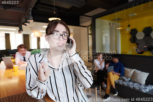 Image of portrait of businesswoman with glasses using mobile phone