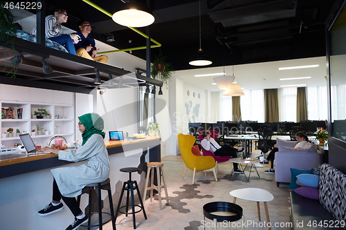 Image of group of casual multiethnic business people taking break from th