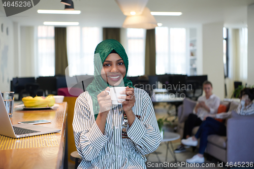 Image of african muslim business woman drinking tea